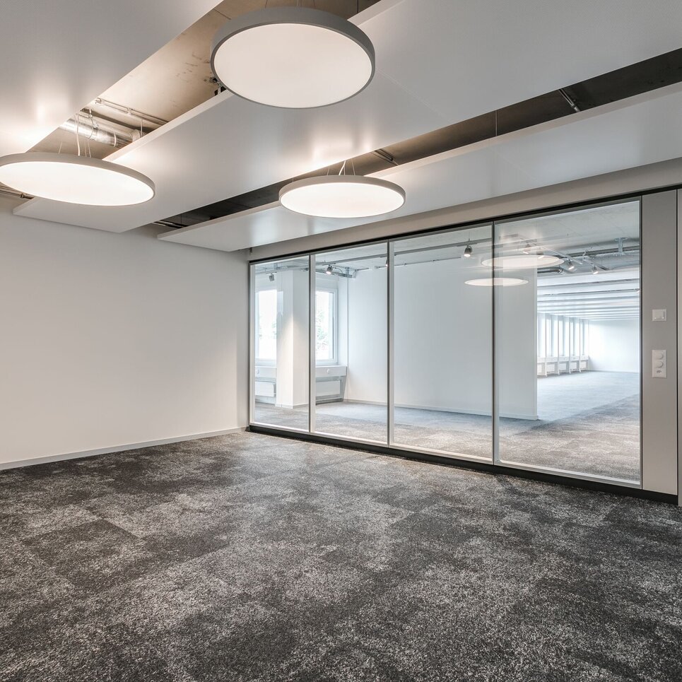 Leerer Bürosaal mit grossen runden Deckenlampen